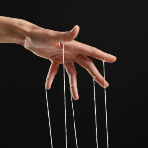 Hand hält Fäden. Suggeriert die Konditionierung in einer Hypnose